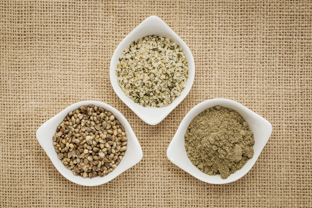 Picture of whole, split and ground hemp seeds in bowls