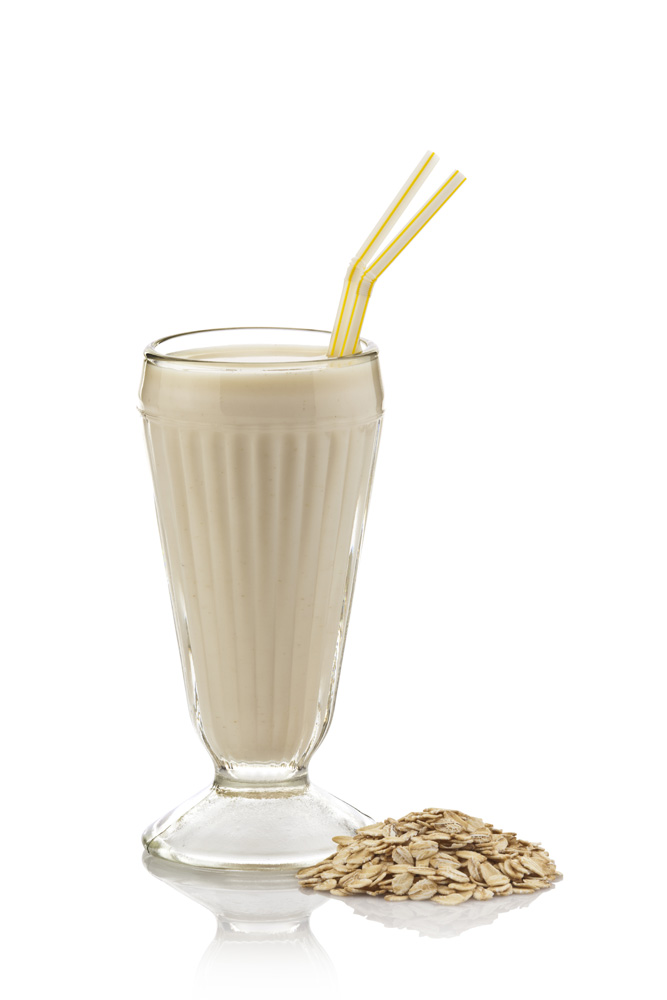 Image d’un verre de lait frappé à base d’avoine contenant deux pailles jaunes, sur fond blanc