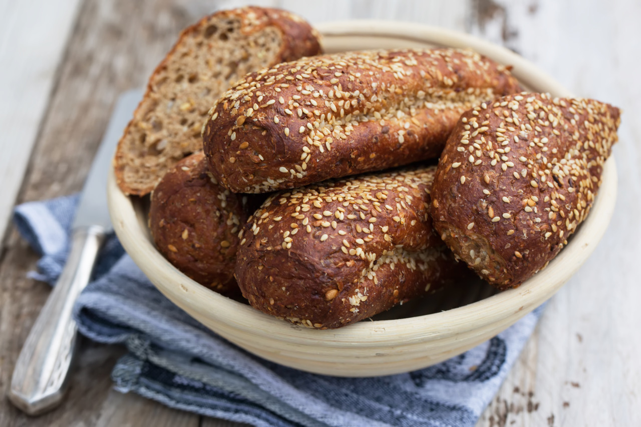 picture of five loaf of breads garnished with sesame seeds in a bowl 