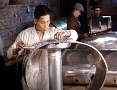 des hommes dans une usine travaillent sur de gros objets mtalliques ronds