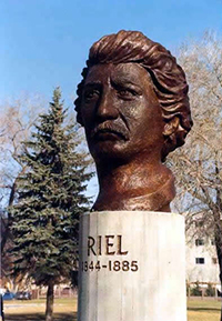 Bronze bust of the face of Louis Riel. Bust is on a pedastal that reads RIEL 1844-1885.