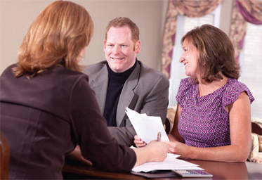 three people sitting around a table smiling