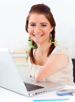 woman with a partial arm using a computer and smiling at the camera