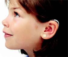 girl with a hearing aid smiling