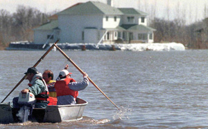 Three men boating in a flooded residential area, 1997