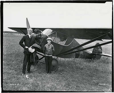 un homme et un garçon à côté d'un avion des années 1920